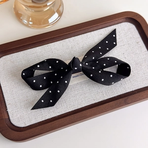 Détail d'un nœud papillon à pois noirs et blancs sur un plateau en bois élégant