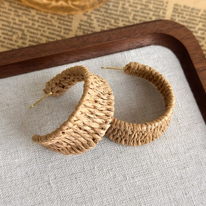 Detail von handgefertigten Boho-Bast-Ohrringen auf einem Vintage-Tablett
