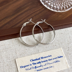 Detail of S925 sterling silver hoop earrings with frosted texture and hinged clasp