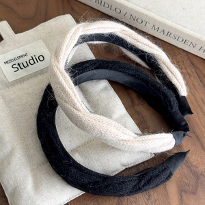Winter chunky knit and plush headband set in cream and black on a textured wooden desk