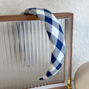 Detailed close-up of blue plaid padded headband with soft fabric texture on display