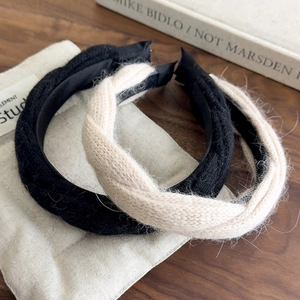 Detail view of knitted twist headband texture in black and beige with a soft plush finish