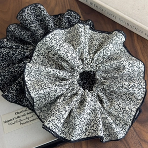 Lot de chouchous géants à fleurs noir et blanc sur fond de bois au style rétro chic