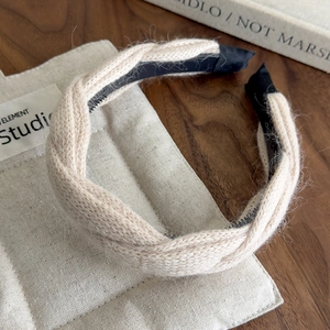 Close-up of beige knitted twist headband showing soft wool texture and non-slip inner teeth