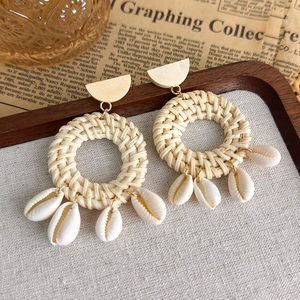 Detail von böhmischen handgefertigten Strohohrringen mit Muscheln und Holzstücken