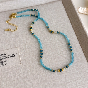 Detailaufnahme der blauen Perlenkette mit goldenem Karabiner und Verlängerungskette