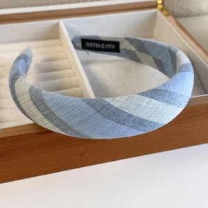 Detail of blue plaid fabric headband featuring a black handmade label on inner side