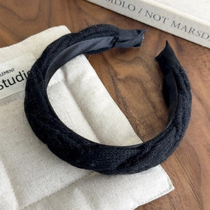Detail shot of black knitted headband with soft texture and comfortable fabric wrap ends
