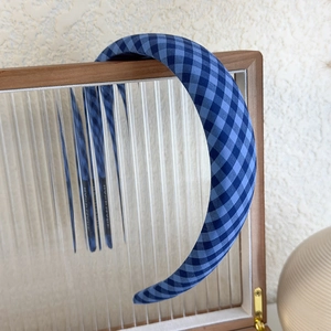 Detail of blue plaid headband showing the handmade label and non-slip inner lining