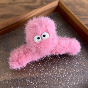 Detail of cute large eyes plush shark hair claw clip in bright pink fuzzy texture