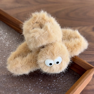Detailed view of the soft plush shark clip with cute big eyes in light camel brown