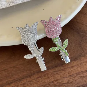 Sparkling tulip rhinestone hair clips with floral crystal inlay on a wooden surface
