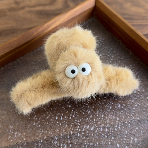 Close-up of soft camel plush shark hair clip with quirky big eye elements and sturdy grip