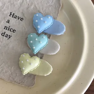 Lot de trois pinces à cheveux coeur colorées avec perles et base enveloppée de tissu