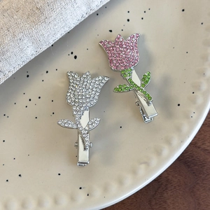 Sparkling crystal tulip hair clips set with rhinestone inlay on light beige ceramic plate