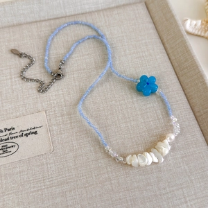 Detailansicht der blauen Perlen, Muschelstücke und Blumenanhänger der Sommerkette
