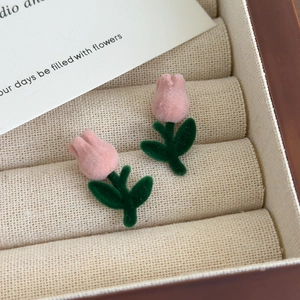 Close-up of velvet tulip earrings with soft pink and green flocking texture detail