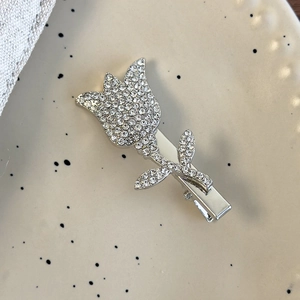 Detailed view of tulip hair clip with sparkling white rhinestones on silver metal base