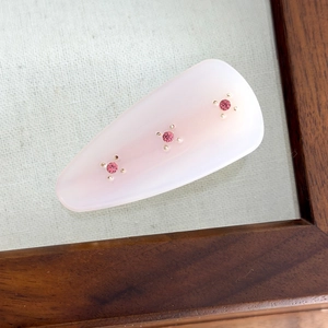 Macro detail of teardrop hair clip with pink gradient acetate and rhinestone inlay