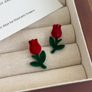 Macro shot of red tulip earrings with high-quality velvet texture in a jewelry box