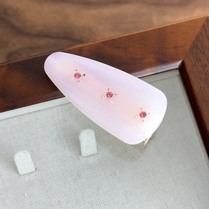 Detail of pink drop-shaped acetate hair clip with three sparkling rhinestones
