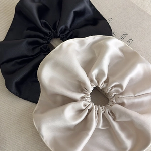 Détails de chouchous en satin noir et champagne sur un fond texturé élégant
