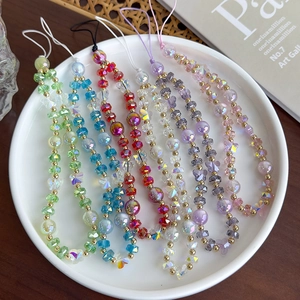 Détail de bijoux de téléphone en perles de verre colorées avec papillon et perles dorées