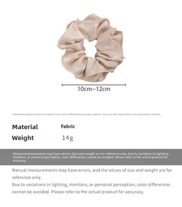 Detail of champagne satin scrunchie with handcrafted pearl beads and ruffled edges
