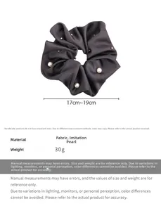 Detail showing grey satin scrunchie with faux pearl studs and smooth silk texture