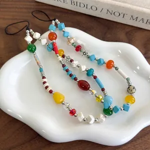 Colorful handmade stone beaded phone strap with bohemian style on ceramic tray