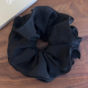 Gros plan d'un grand chouchou noir à 4 couches avec texture plissée dentelle