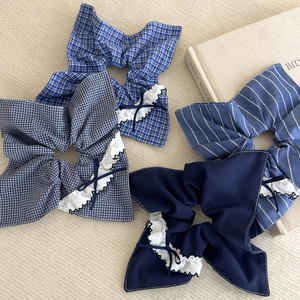 Détail de quatre chouchous à carreaux bleus avec bordure en dentelle et petit nœud déco