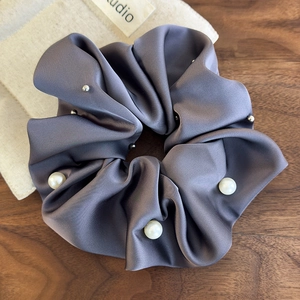 Detailed view of grey-purple satin scrunchie with large pearls and silver beads