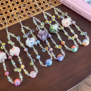 Detail of multi-colored beaded phone lanyards with fabric bows and flower charms