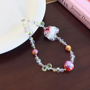 Detail view of handmade beaded phone strap with lace bow and resin flower charm