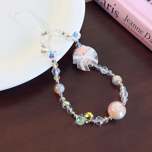 Detailed close-up of a beaded phone wrist strap with pink fabric rose and lace bow