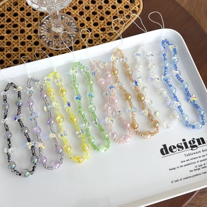 Vue détaillée de dragonnes de téléphone en perles colorées avec papillons en acrylique