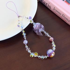 Close-up of purple beaded phone wrist strap with crystal flower and silk ribbon bow
