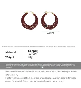 Detail view of burgundy enamel hoop earrings with copper and zircon stone accents