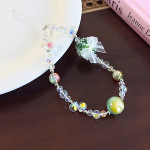Detail of beaded wrist strap featuring colorful glass beads and a green flower charm