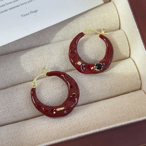 Macro detail of vintage red lava texture hoop earrings with gold-plated finish