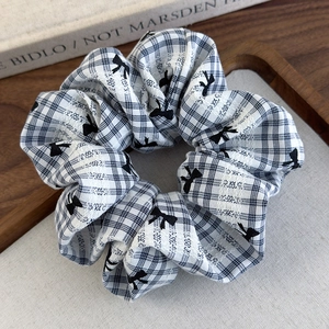 Gros plan d'un chouchou à carreaux noir et blanc avec motifs de nœuds sur bois vintage