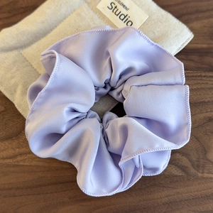 Detailed view of large lavender satin scrunchie with layered pleats and premium silk texture