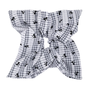 Détail du chouchou en tissu à carreaux noirs et blancs avec motifs nœuds