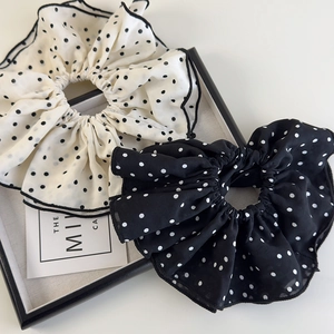 Detailed shot of large black and white polka dot chiffon scrunchies in a display tray
