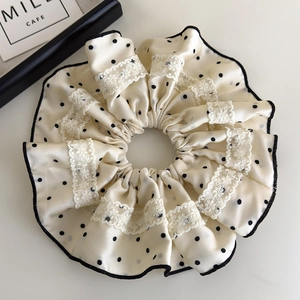 Close-up of French style polka dot satin hair scrunchie with delicate lace details