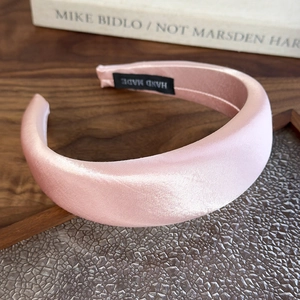 Detail of light pink satin padded headband with premium handmade interior label