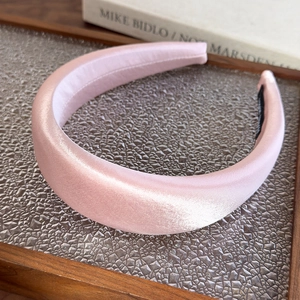 Detailed view of pink satin padded headband with premium smooth texture and high-density foam