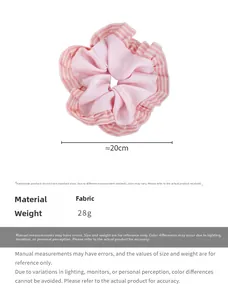 Détail d'un chouchou en satin rose avec bords plissés à rayures blanches et texture