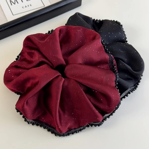 Détail de chouchous en satin bordeaux et noir avec paillettes et bords perlés